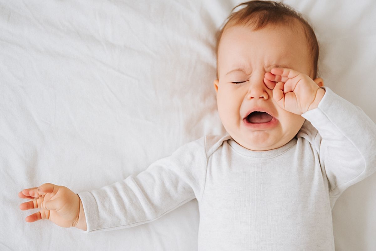 Müdes Baby liegt entspannt in einer warmen, ruhigen Umgebung – Symbol für Übermüdung und Geborgenheit im Alltag.